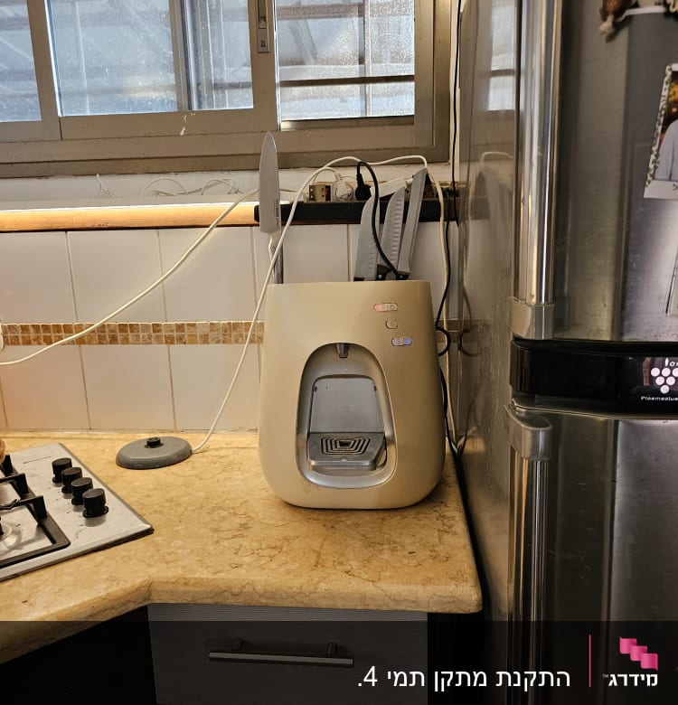 מכשיר מים על השיש במטבח ליד חלון